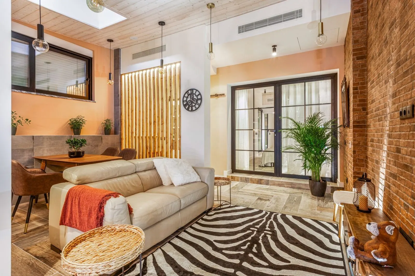 Open-plan living area with exposed brick and wood ceiling — Amoreira loft conversion Cascais by Maya's Homes