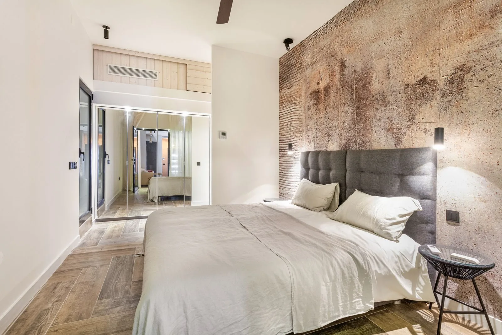 Master bedroom with cement feature wall and pendant lights — Amoreira loft conversion Cascais by Maya's Homes