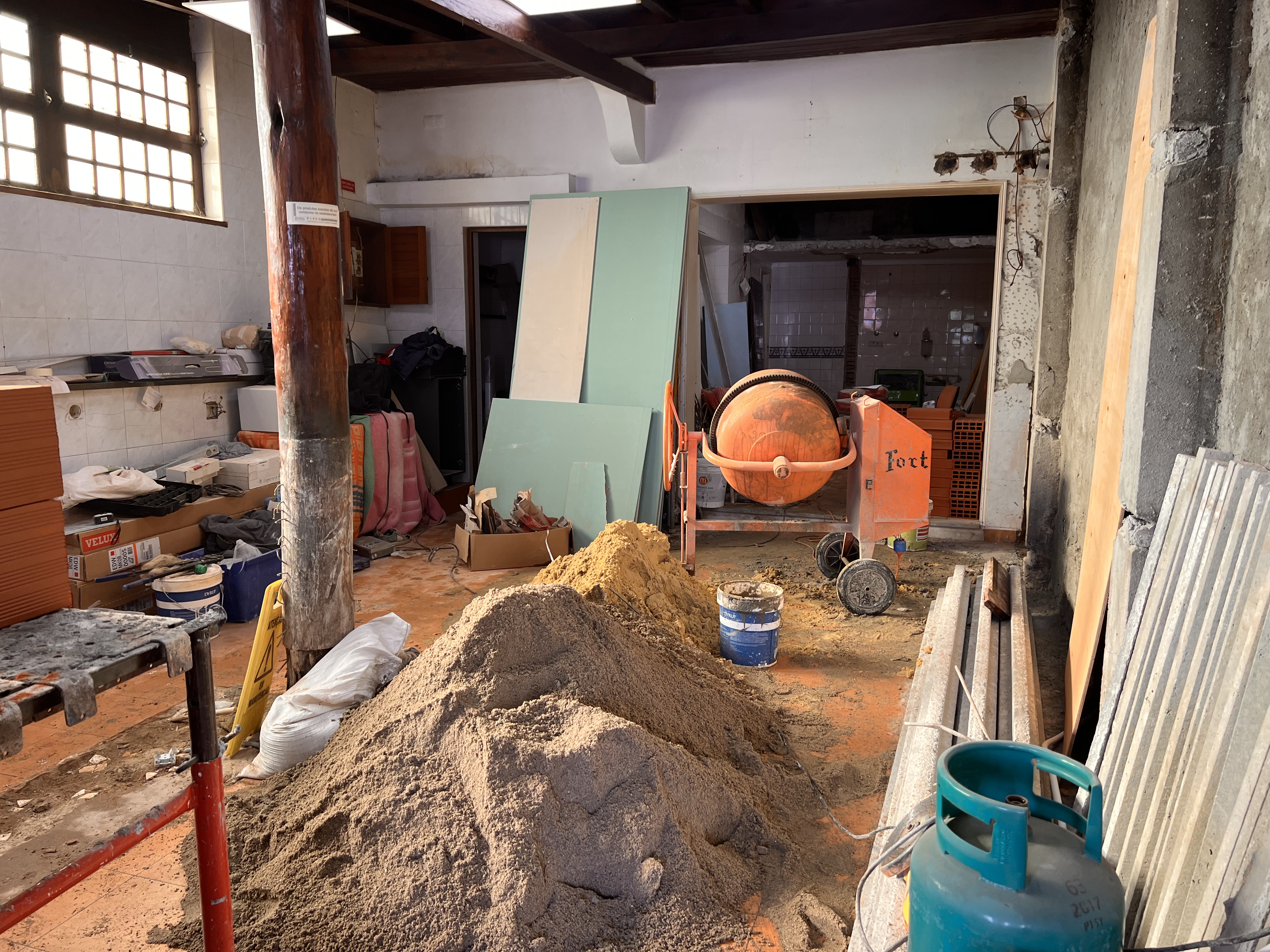 The Tasca during &mdash; the tavern interior stripped to its bones, sand piled for mortar, cement mixer in place, the original timber post standing