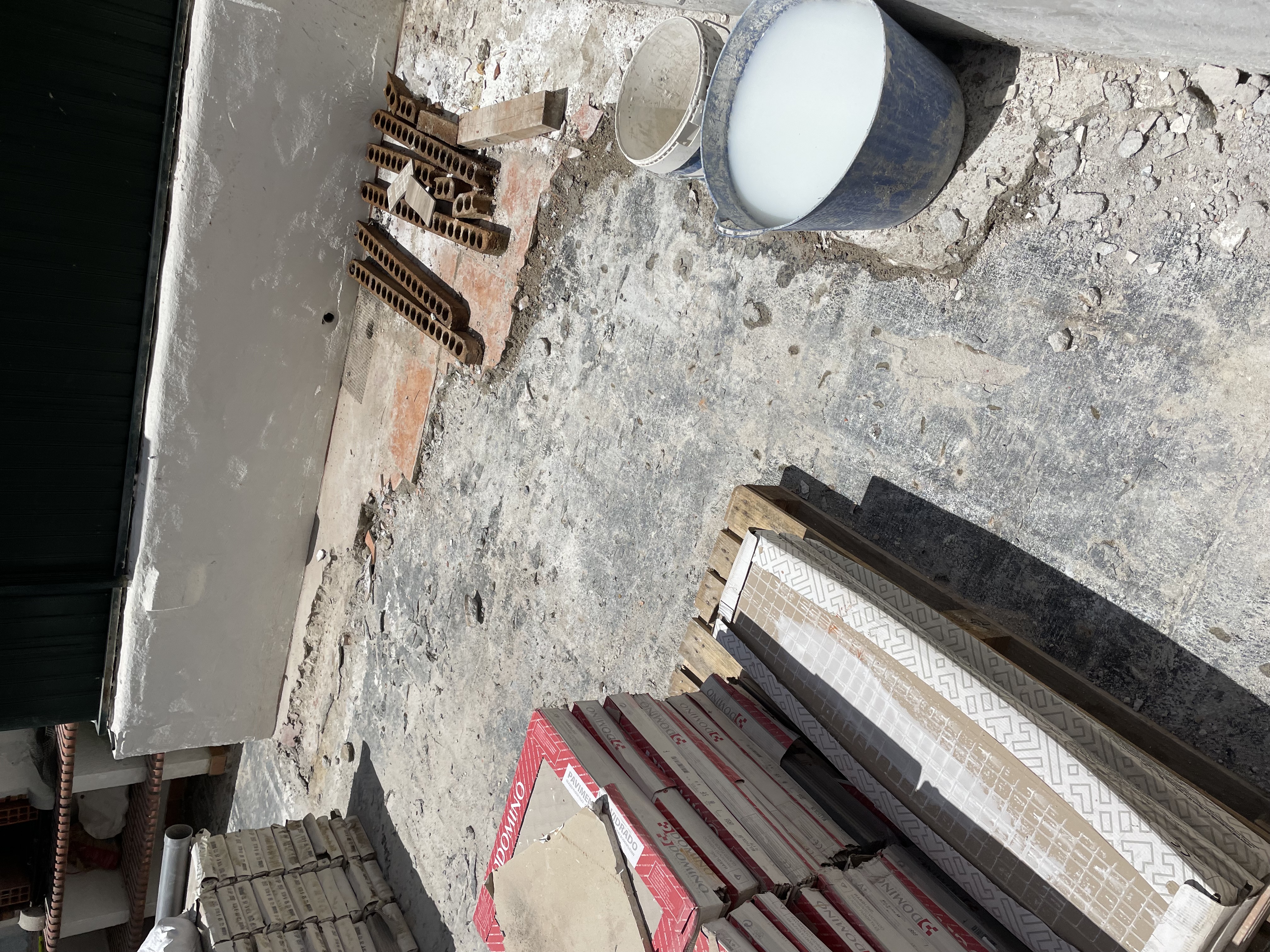 Rosa during &mdash; original tiles fully stripped and stacked at the perimeter, the exposed substrate ready for waterproofing