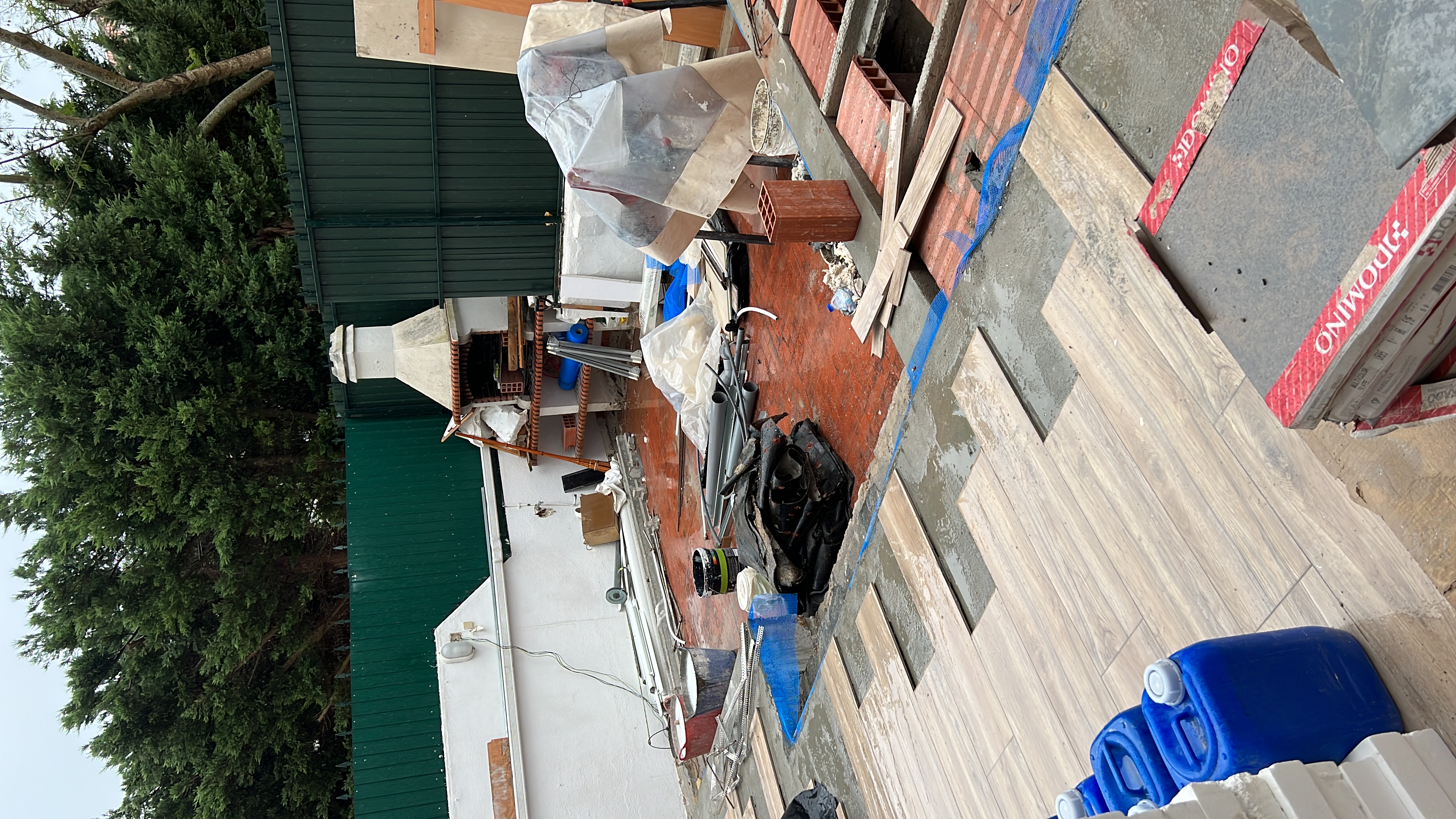 Rosa during &mdash; wood-effect floor tiles arriving on site in their packaging, staged against the new substructure, ready to be installed
