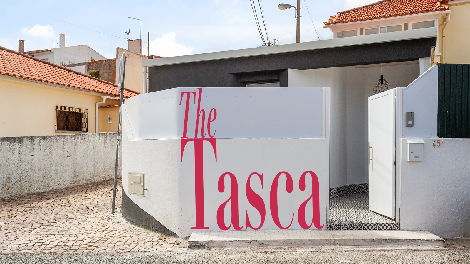 The Tasca &mdash; a porta aberta deixa ver a tasca convertida com paredes em terracota, caixilharia preta em metal, suspens&otilde;es em lat&atilde;o, soalho em parquet de carvalho