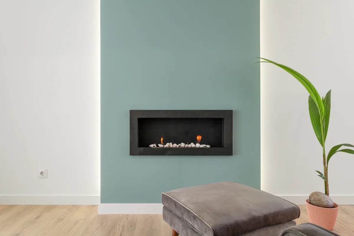 La Sala — Lareira encastrada numa parede verde.