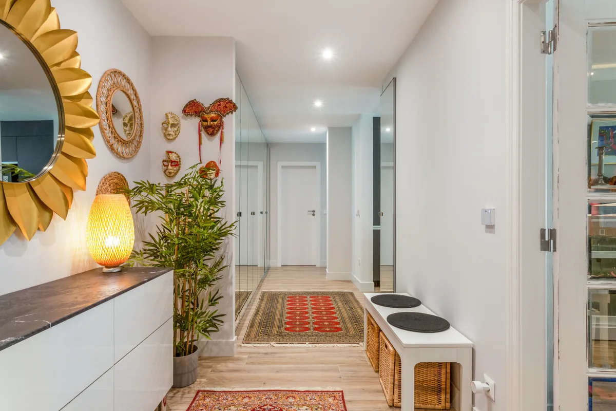 Rosa — Entrance hallway with decorative mirrors and a long rug.
