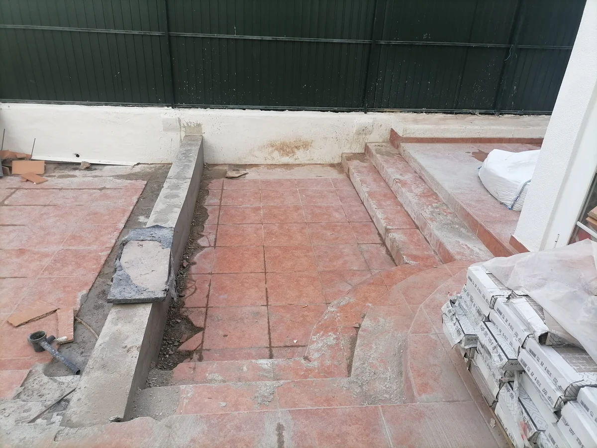Rosa during &mdash; old terrace tiles removed, with cement strips forming the new base