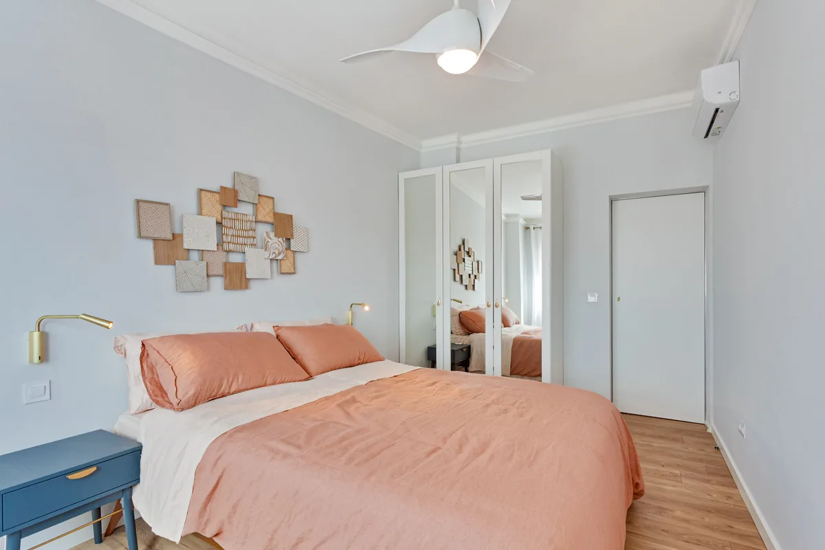 Vista — Bedroom with a pink bedspread and mirrored wardrobe.