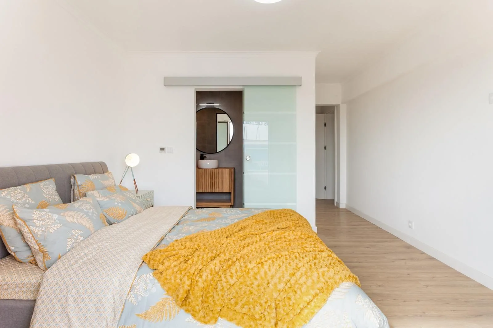 Master suite with glass partition to ensuite bathroom — Rebelva apartment renovation by Maya's Homes