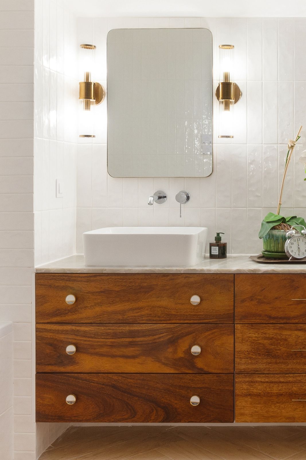 Vanity detail — walnut drawers with brass sconces
