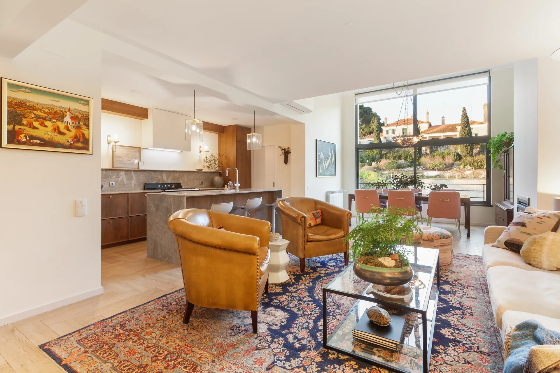 Open-plan living room with leather chairs and Persian rug — Riviera villa renovation Cascais by Maya's Homes